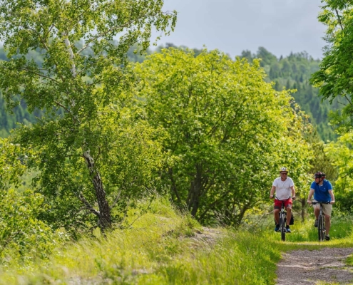 Two persons riding bicycles on a gravel road