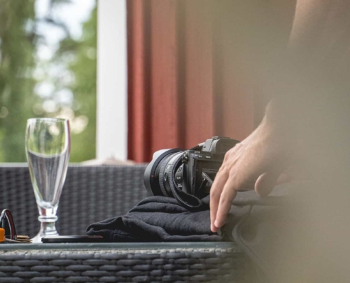 behind the scenes image of a person filming a glass