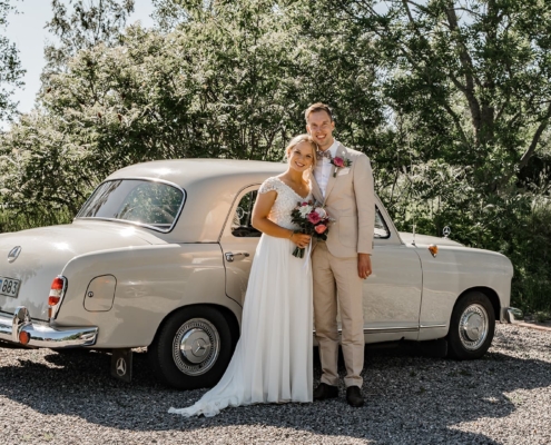 wedding couple in front of an old classic car