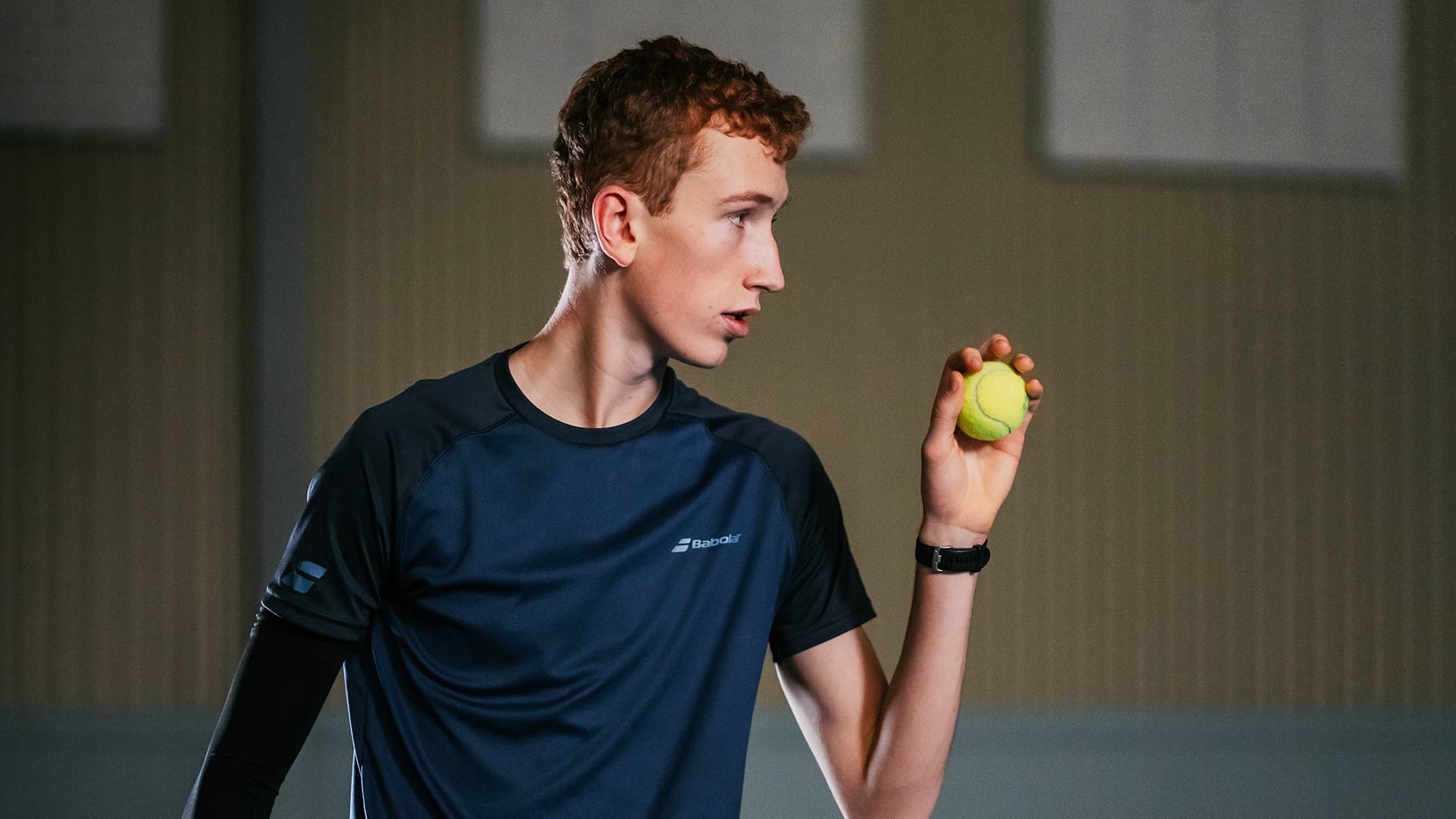 tennis player holding the ball looking focused