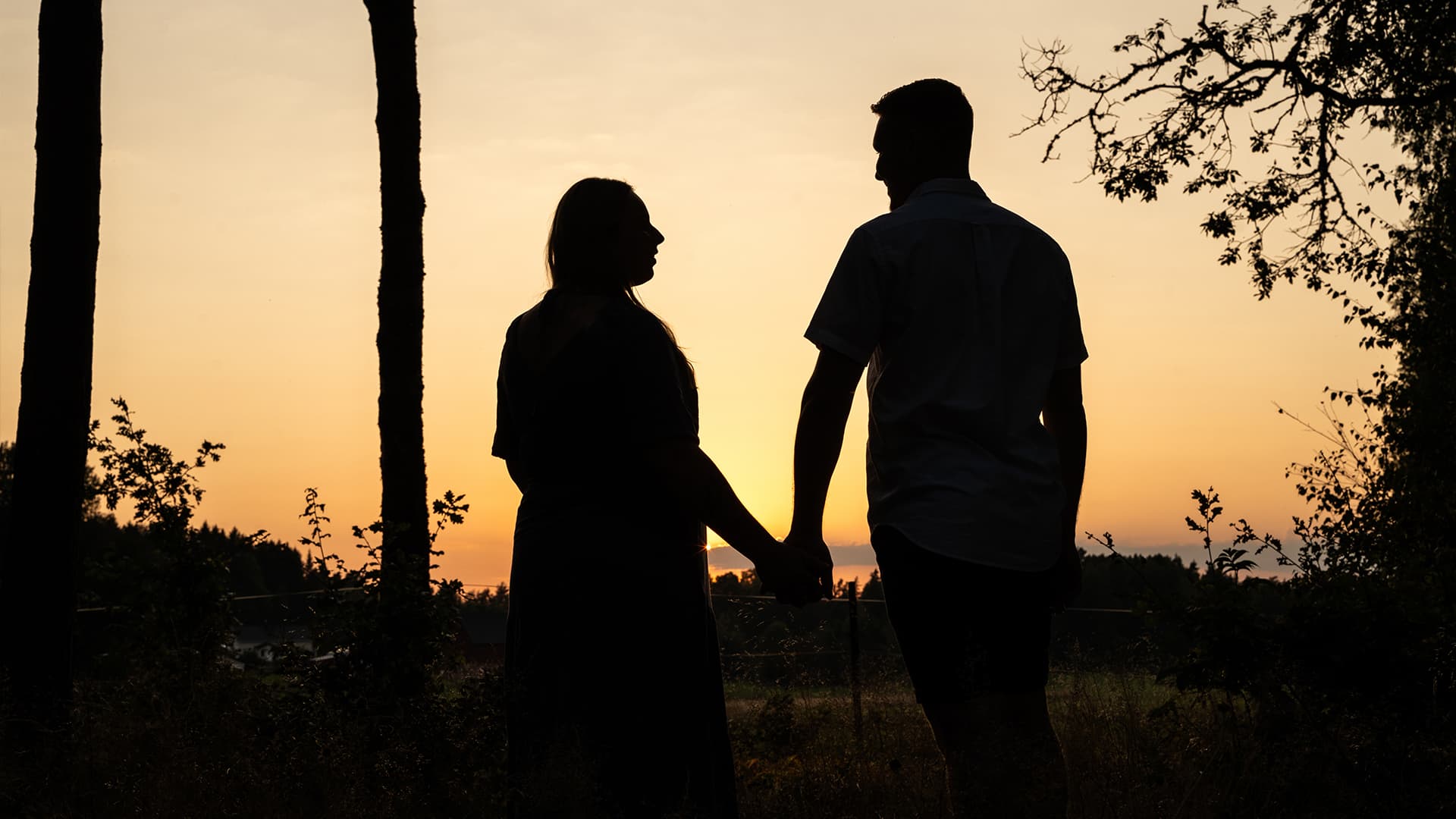 silhouette of two people during sunset