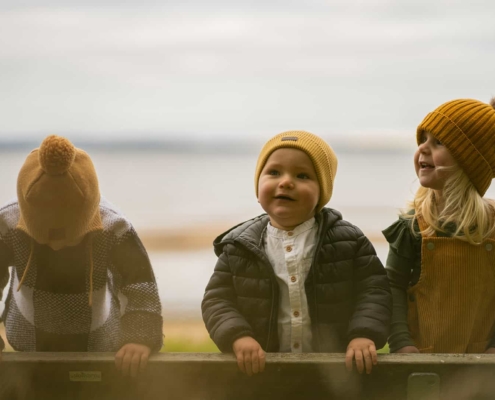 three kids playing at a beach