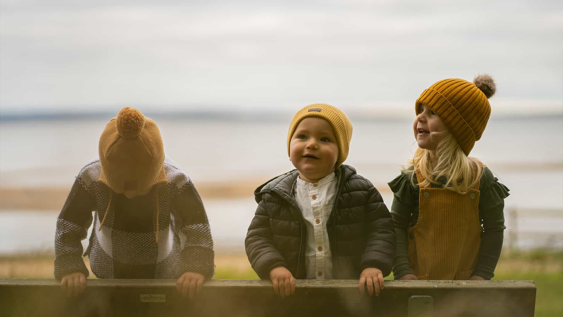 three kids playing at a beach