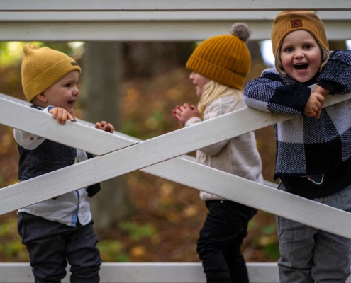 three kids playing in a forest