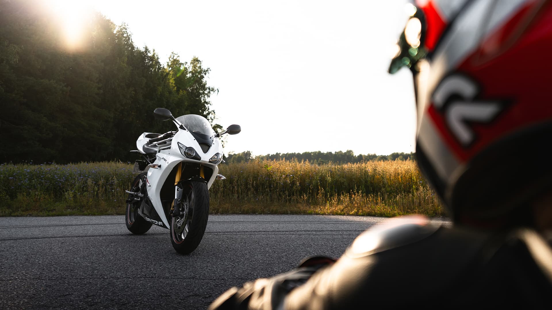 Person looking at a sportbike during sunset