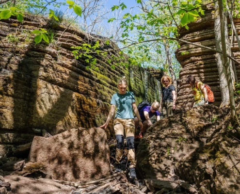 People climbing down a tiny waterfall at Kinnekulle