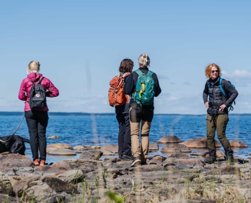 People and a dog out hiking by Lake Vänern