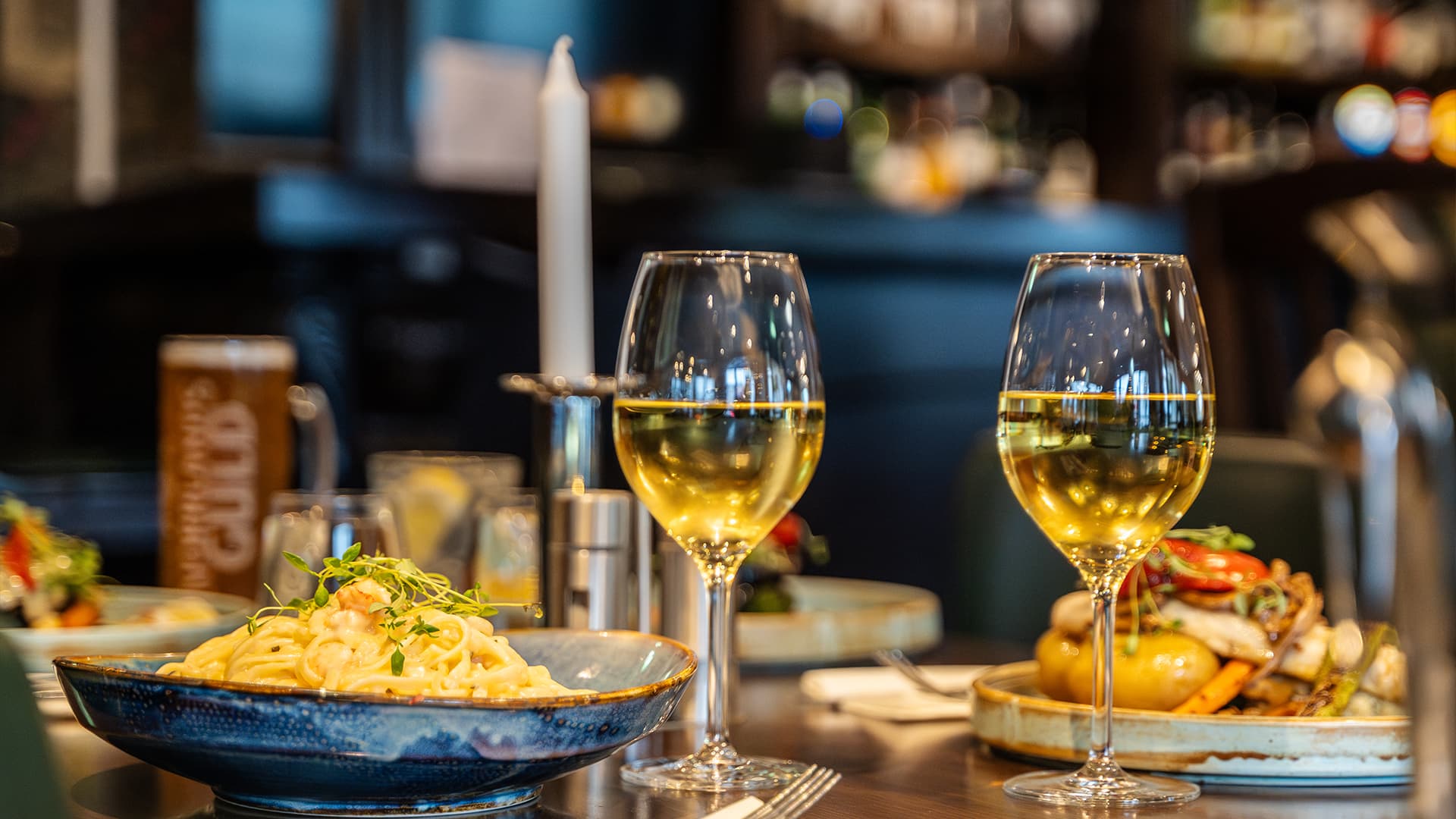 close up of two glasses of wine and food in a restaurant