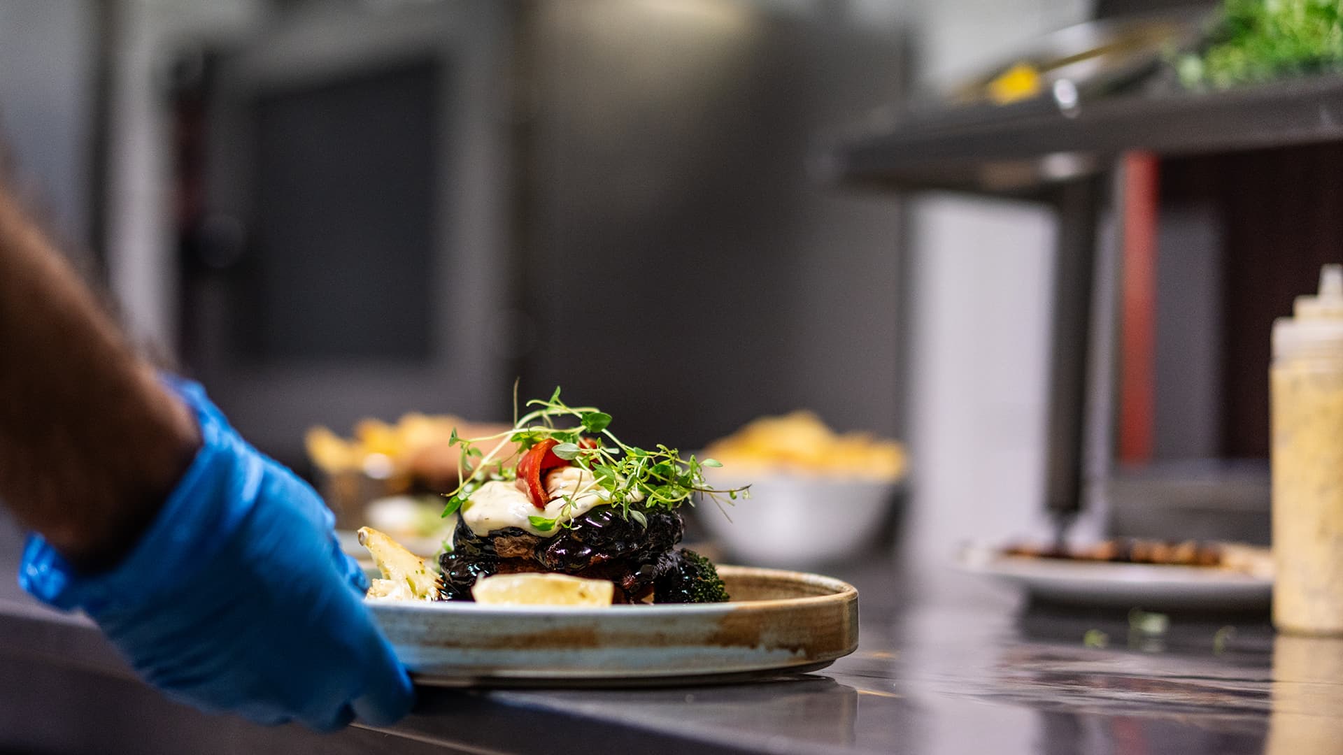 close up of a chef taking a plate out for serving