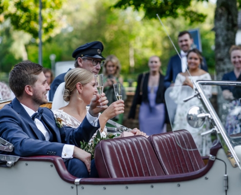 bride and groom doing a toast in the car outside of the church