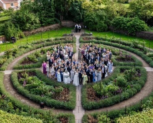 drone shot from above at wedding attendees in a big garden