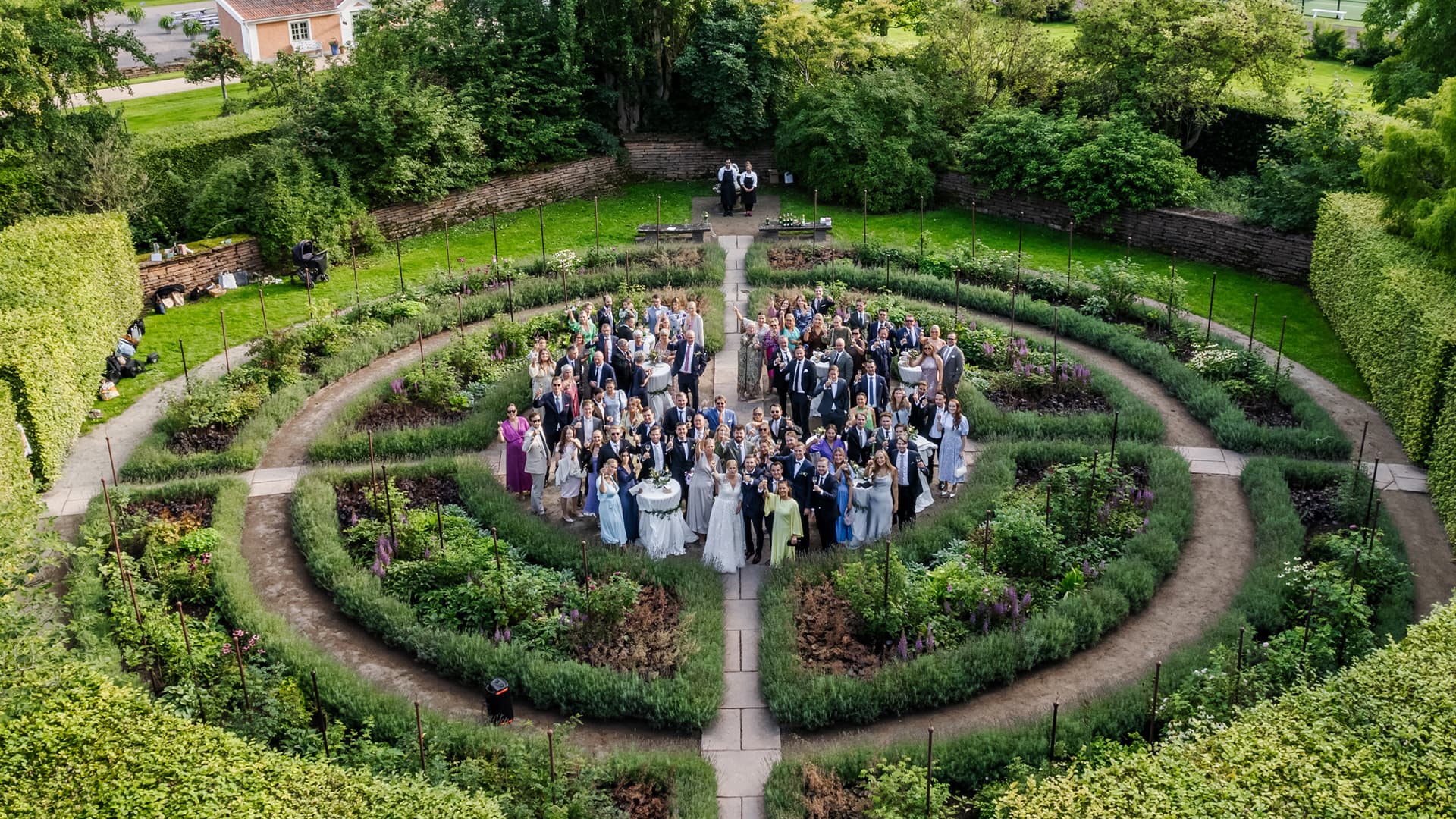 drone shot from above at wedding attendees in a big garden