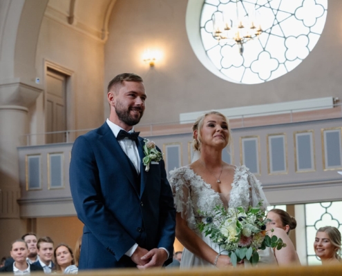 bride and groom in the church talking to the priest