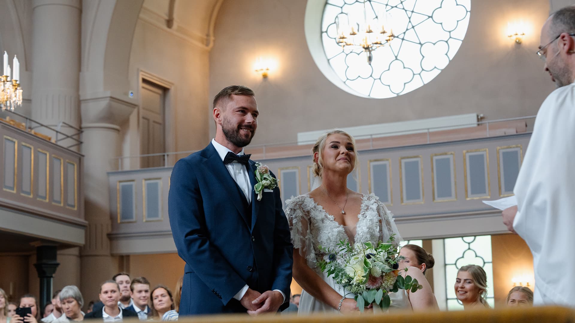 bride and groom in the church talking to the priest