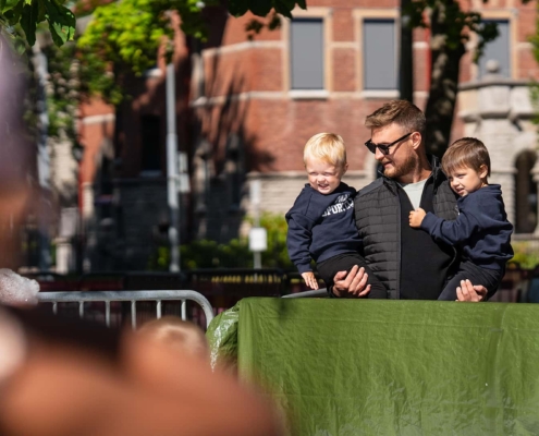 dad carrying his sons at a sunny summer event