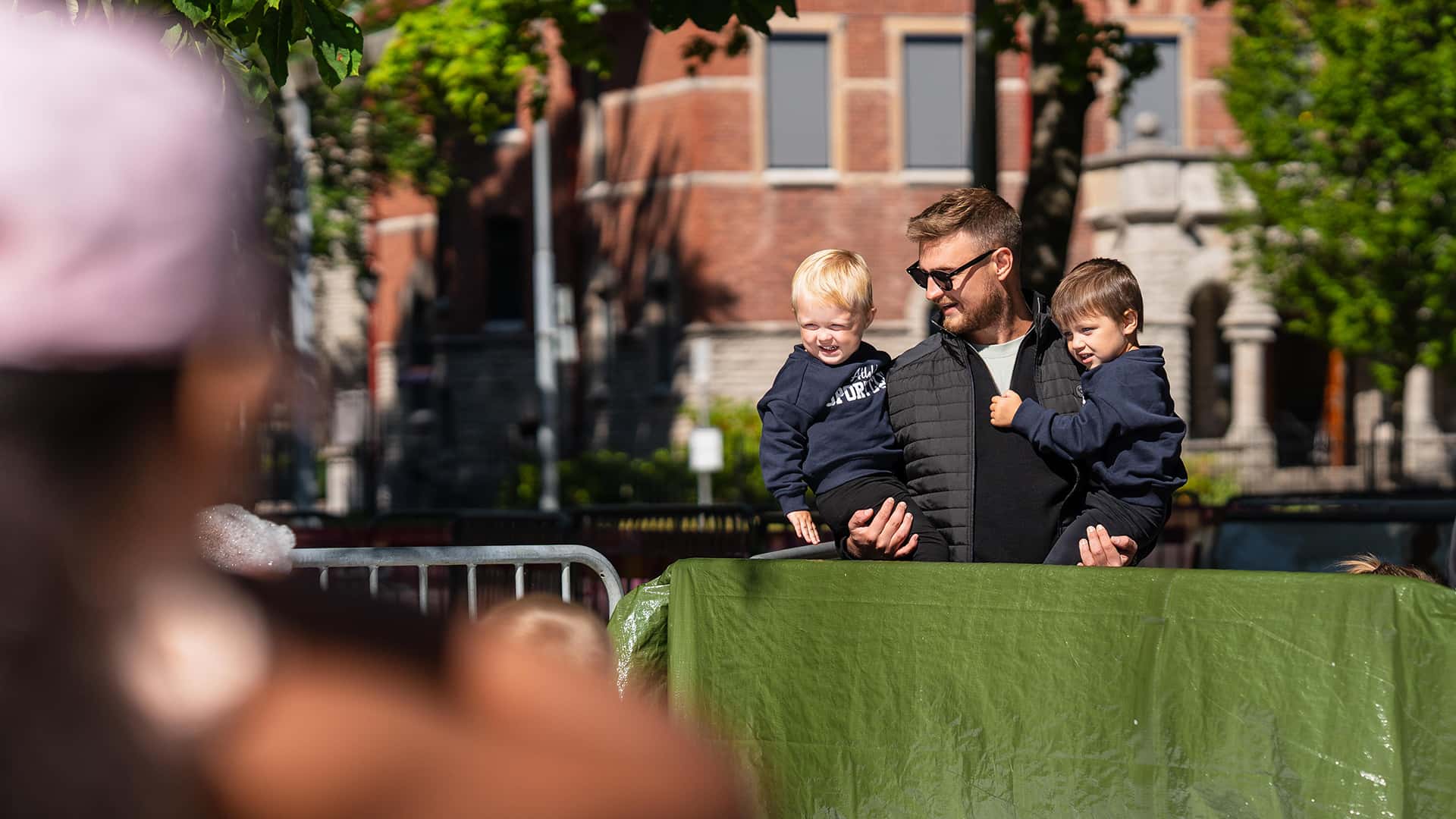 dad carrying his sons at a sunny summer event