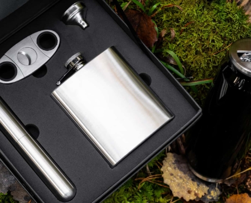close up of a pocket flask in silver with accessories in a case shot in the forest
