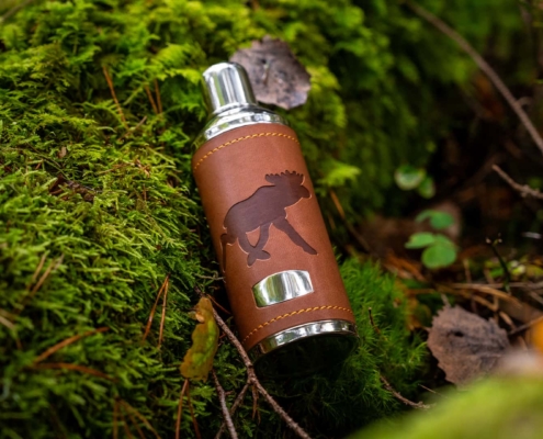 silver water bootle with leather details shot in the forest