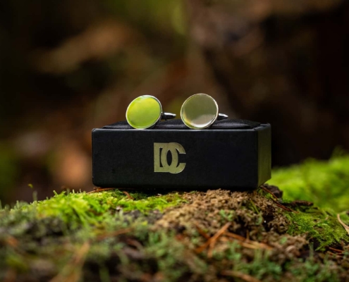 close up of cufflinks in silver on display in a forest