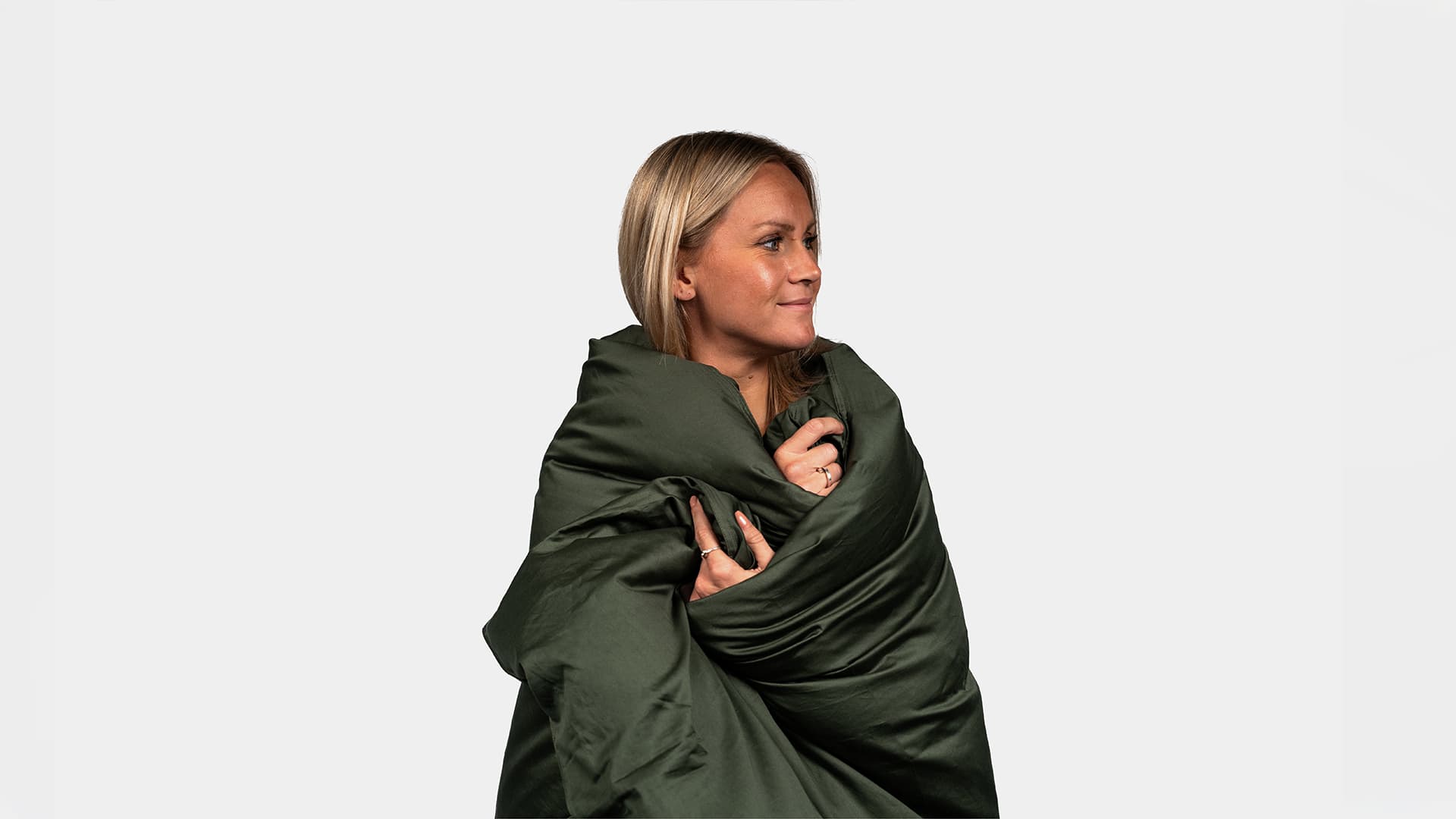woman model being tucked into a duvet in a studio