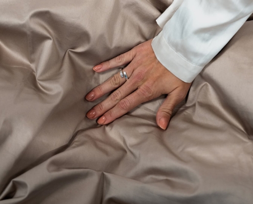 close up of a hand on a duvet