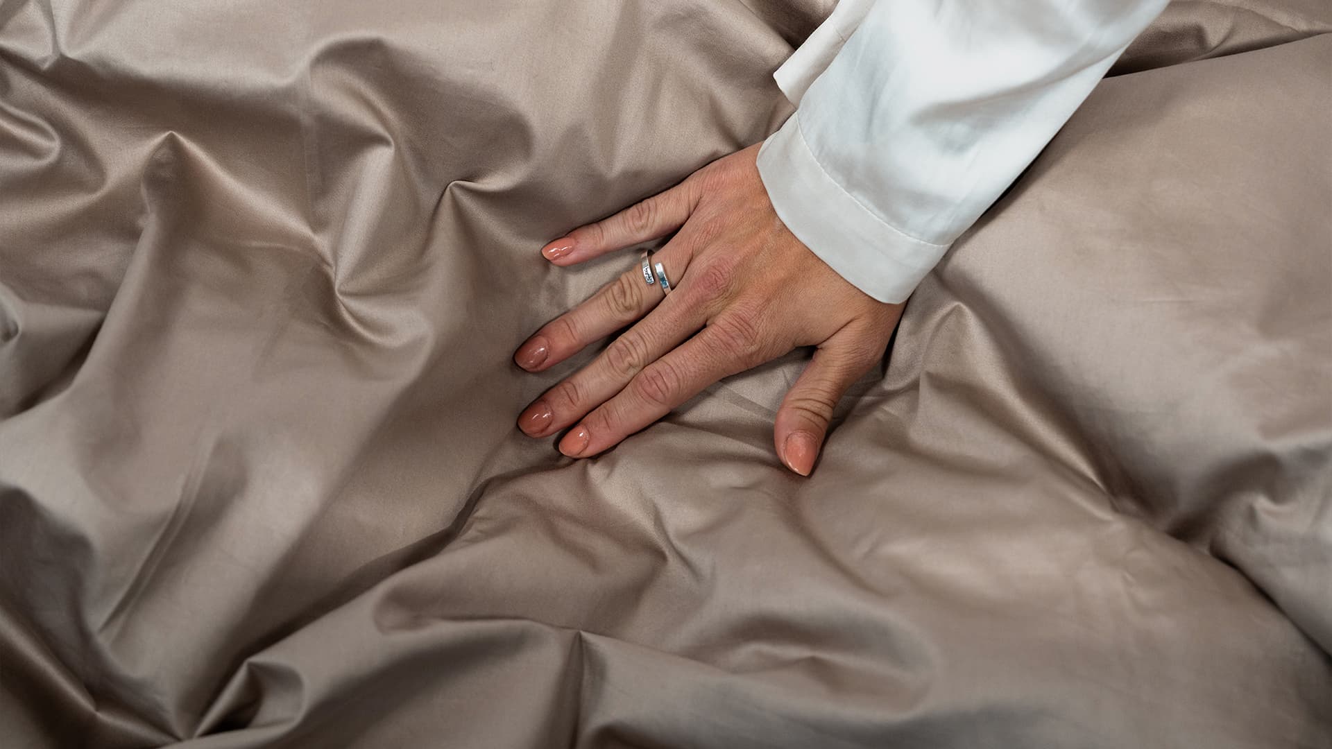 close up of a hand on a duvet