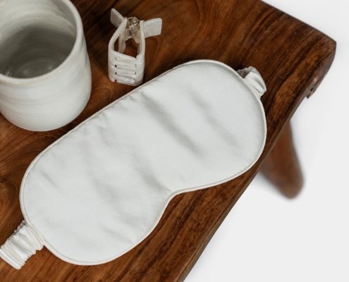 sleeping mask in silk with misc items on a stool