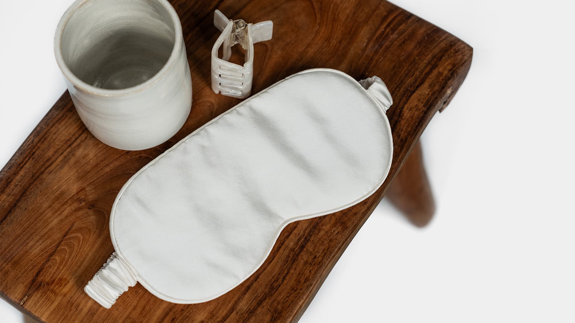 sleeping mask in silk with misc items on a stool