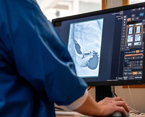 Close up of healthcare personnel working with a X-ray system on a computer screen